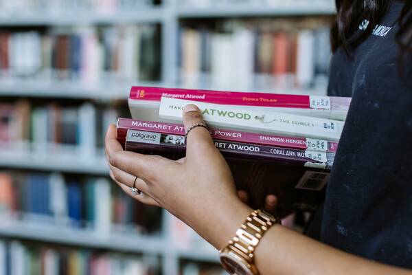 Close up of a student holding some academic books