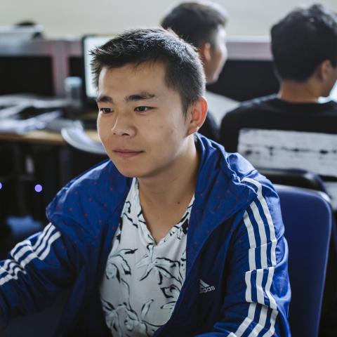 Male student working on computer in computer lab