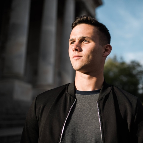 Student looking into distance standing outside the Guildhall