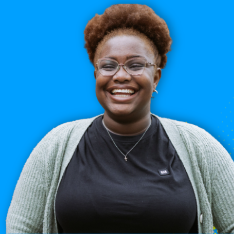 A cutout image of a woman wearing a black top and grey cardigan. The background is bright blue with a fluro dot design. 