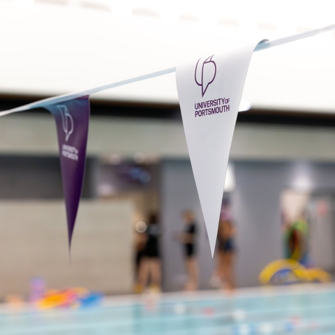 Purple and white bunting with the University of Portsmouth's logo on the flags