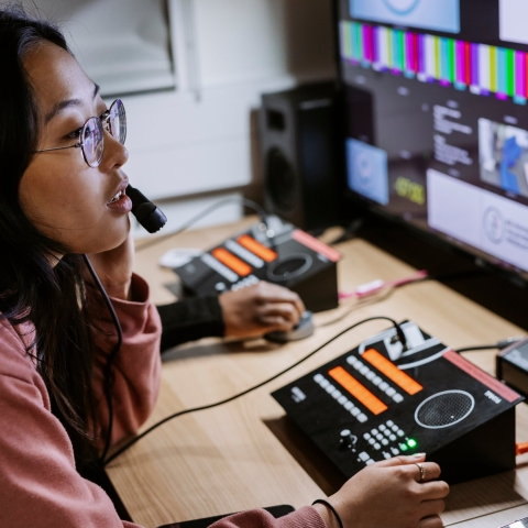 Student in CCI TV Studio Gallery during a live broadcast.
