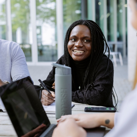 Three students working together with Laptop and Books in Eldon seating area