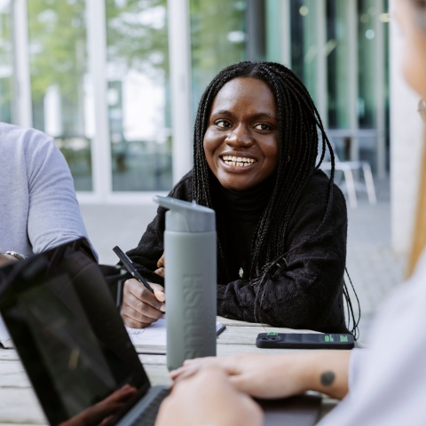 Three students working together with Laptop and Books in Eldon seating area