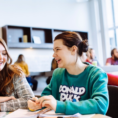 Male and female students studying in University library