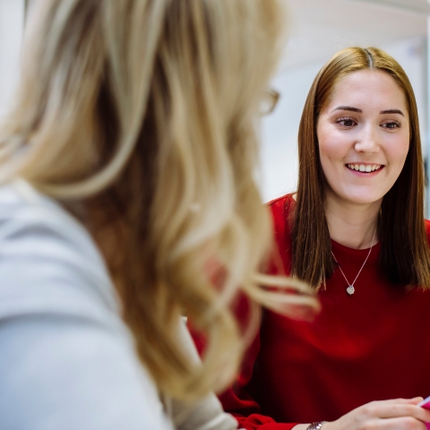 A student smiling in a meeting with her personal tutor