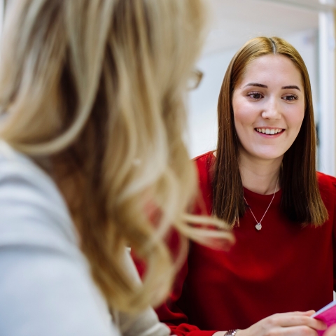 A student smiling in a meeting with her personal tutor