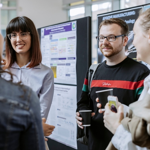 Group photo of PGR students talking inside building.