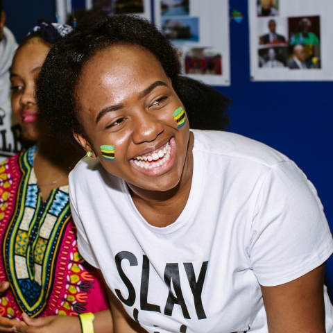 Student smiling, she has Tanzanian flags painted on her cheeks
