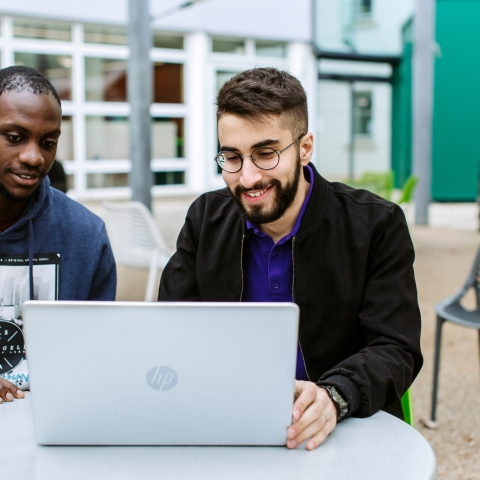 Students looking at a laptop outside Portland Building