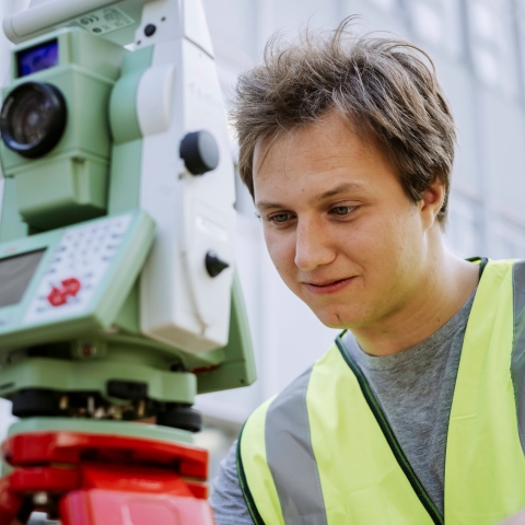 Student conducts measurements using landscape mapping device outside Technology Facilities