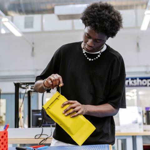 Student using screwdriver on yellow plastic component.Technology Facilities Day One