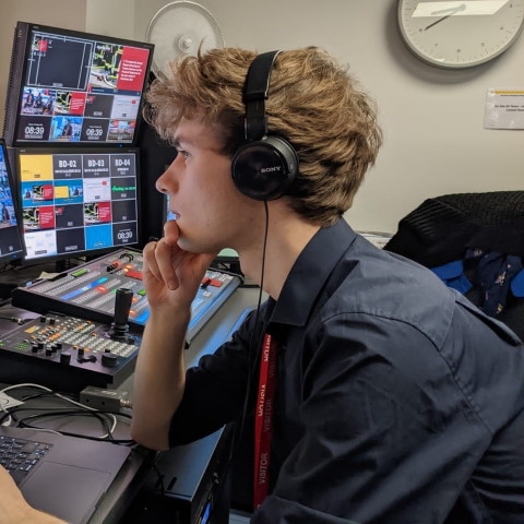 Male at computer desk with headphones