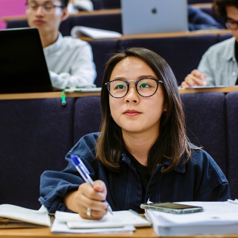 Female student taking notes in lecture
