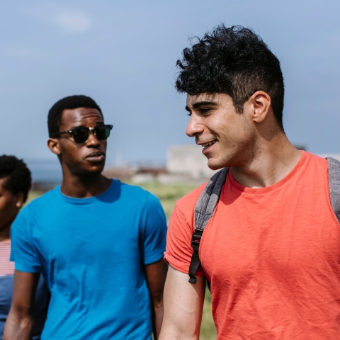  Group of friends walking together on a beach on a sunny day