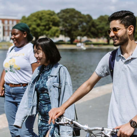 Three students walking by Canoe Lake in Southsea