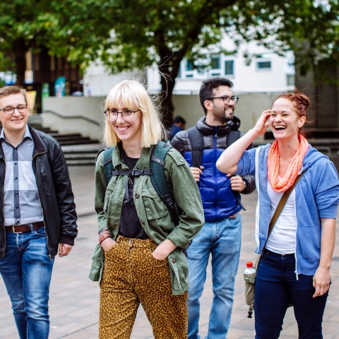 A group of students laughing in Guildhall square