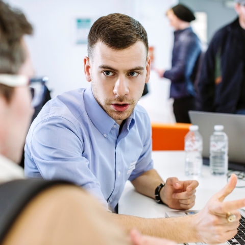 Man talking to another man over papers