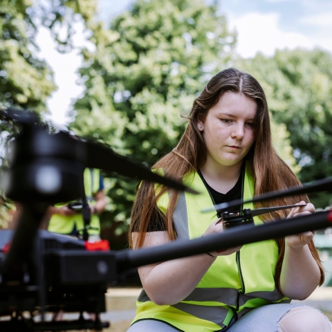 Student kneels next to the drone taking readings on touchpad outside Technology Facilities
Note: The drone is only currently operable by technicians.