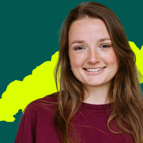 A female student wearing a red top against a dark green background