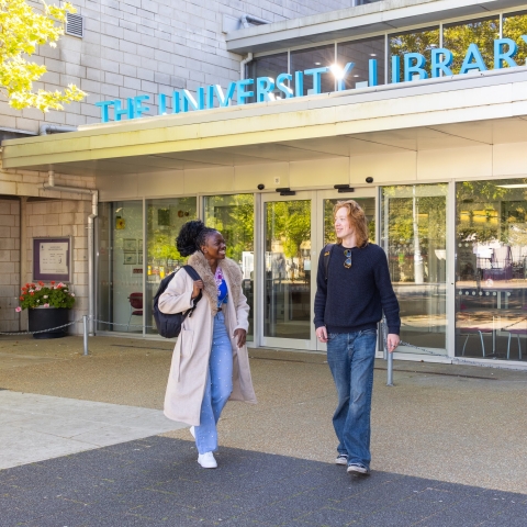 Two students walking outside the University of Portsmouth Library