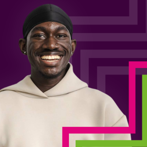 A student smiling in front of a purple background