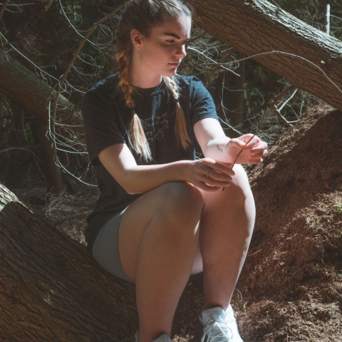 Picture of Eleanor sitting on log