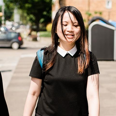 Smiling students walking down street in sun