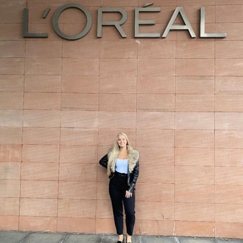 Lauren Windor standing under Loreal sign