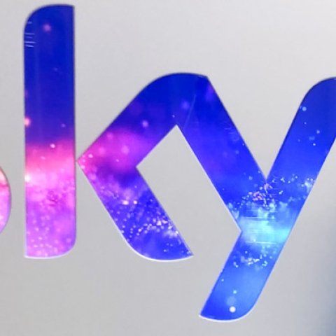 Mary standing next 'Sky' logo