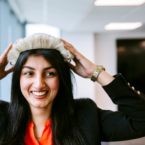 Law student wearing a wig and smiling