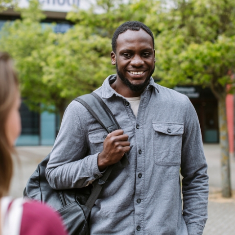 Male student smiling with friend at Northern Quarter