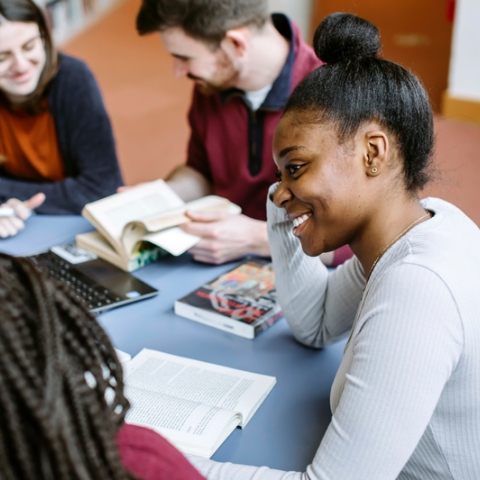 Students in library smiling in group study