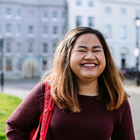 Smiling female student at University of Portsmouth building