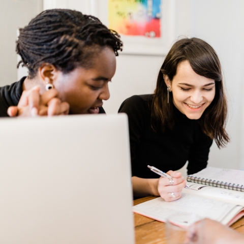 students smiling over coffee at a desk