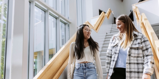 Two students walking down stairs in Eldon building.