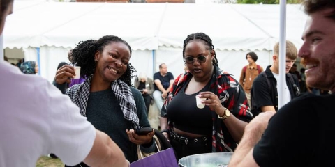 two students trying freebies at welcome festival