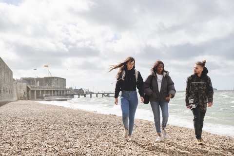 Three students walking on the beach