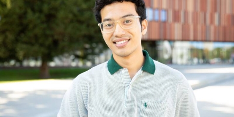 male student wearing glasses stood in front of Ravelin Gym