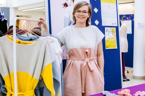 Female University of Portsmouth design student standing by clothing rail