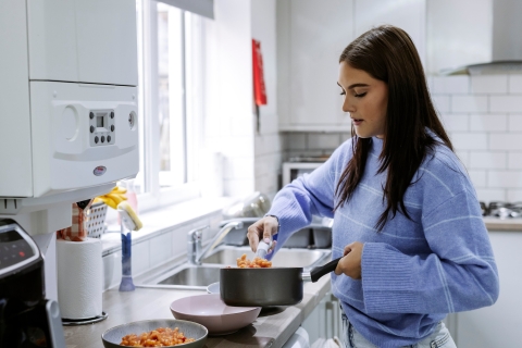 Two people are in the image, smiling and sitting at a table drinking hot drinks