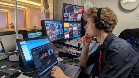 Male studnet with headphones on working on laptop