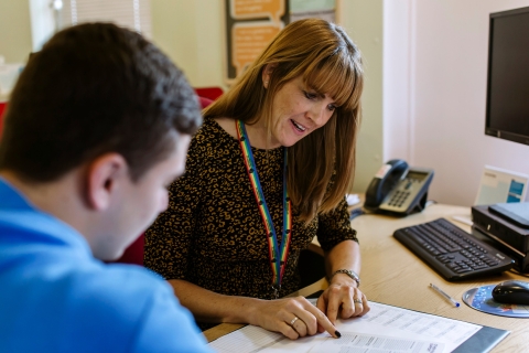Staff member helping student