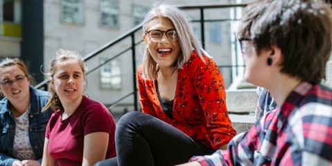 Group of four students sitting and talking