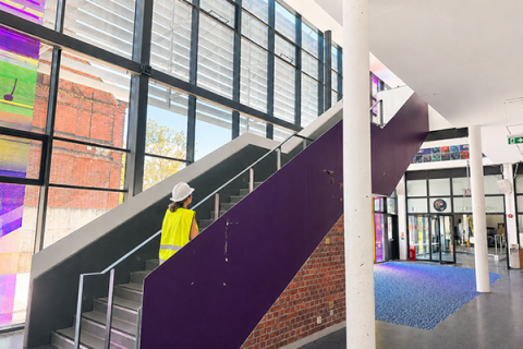 Construction worker walking up the stairs of the Student Centre 