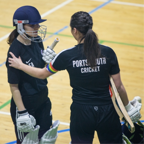 Women's cricket batter congratulating each other