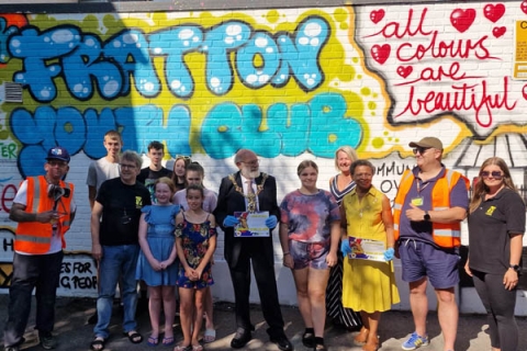 A graffiti wall/ street art with people stood in front