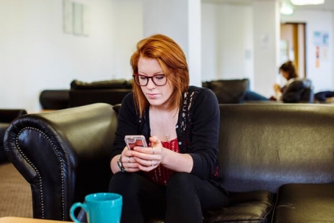 Female student sitting in a communal area in halls