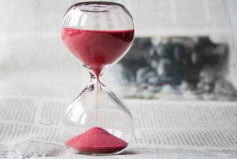 Hourglass with pink sand flowing down