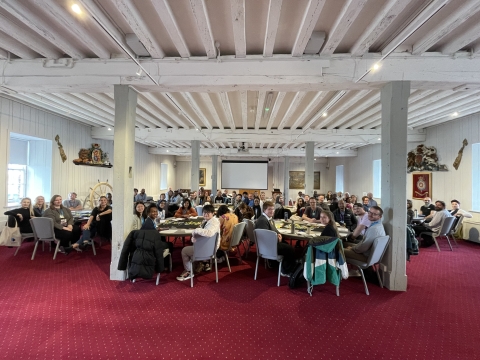 The in-person induction postgraduate students sat at round tables in a big room, posing for a group photo